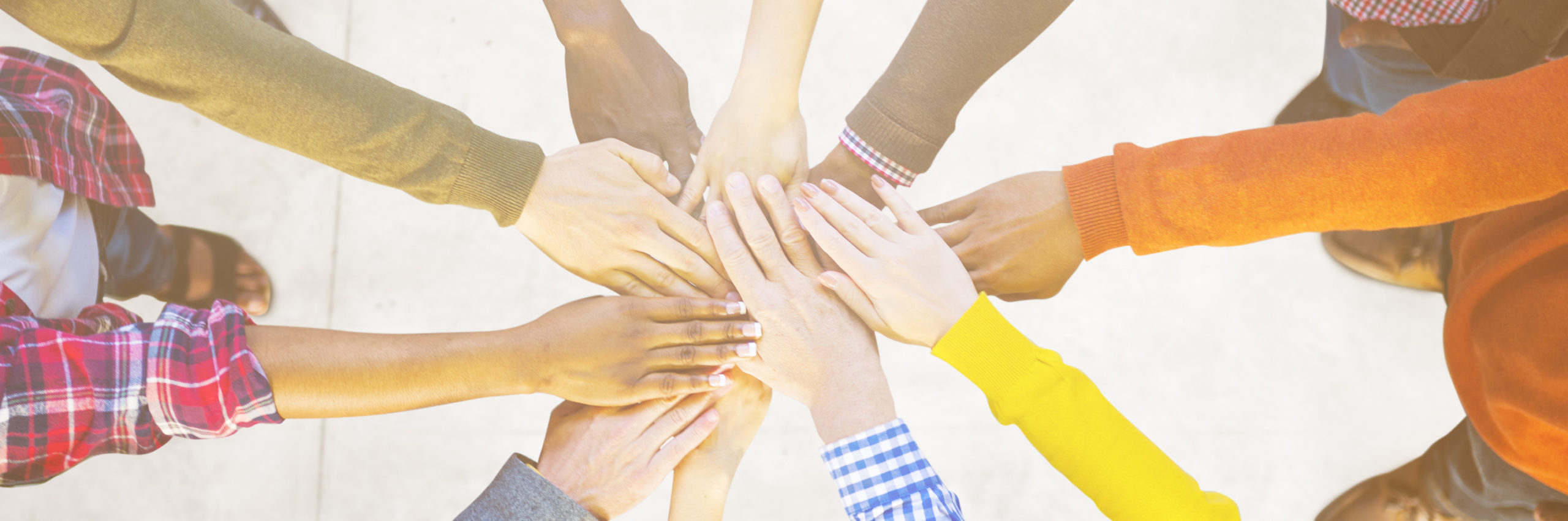 Group of people putting hands together in a circle