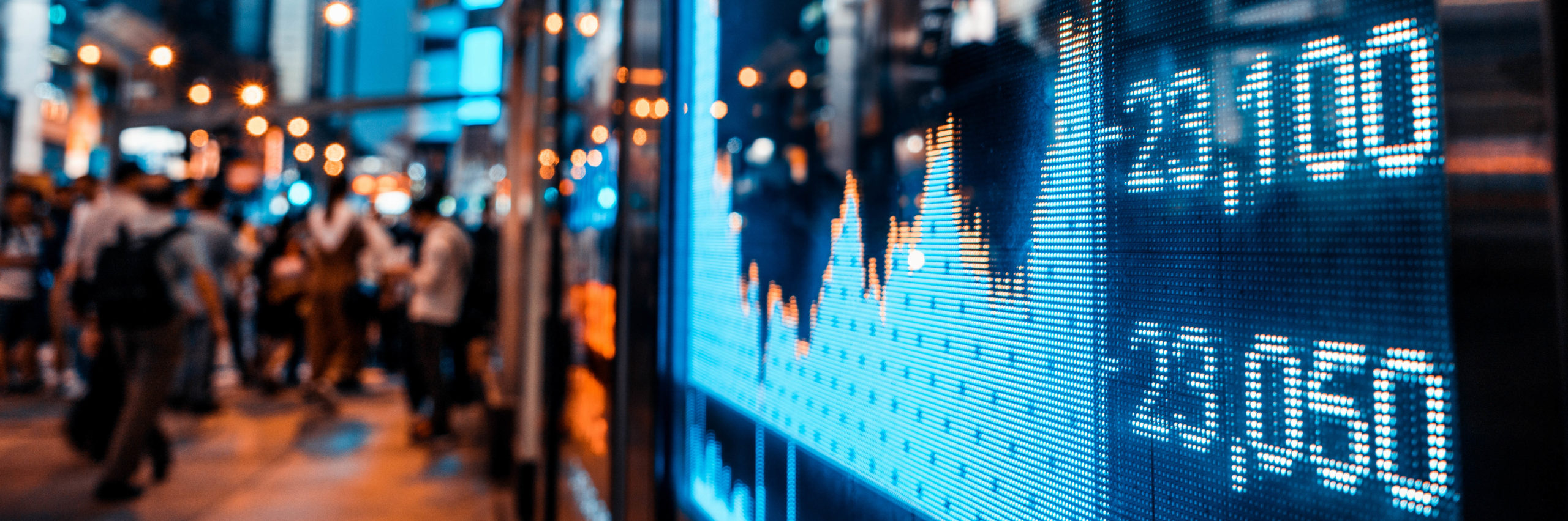 Display of Stock market quotes with city scene reflect on glass - Image [Shutterstock]