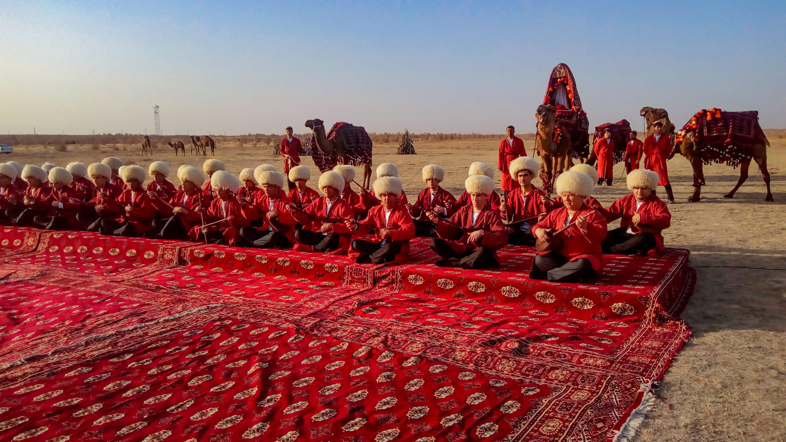 Ashgabat/Turkmenistan-January 25, 2018: Turkmenistan men. Turkmenistan men sitting on the carpet playing national musical instruments. desert. red carpet