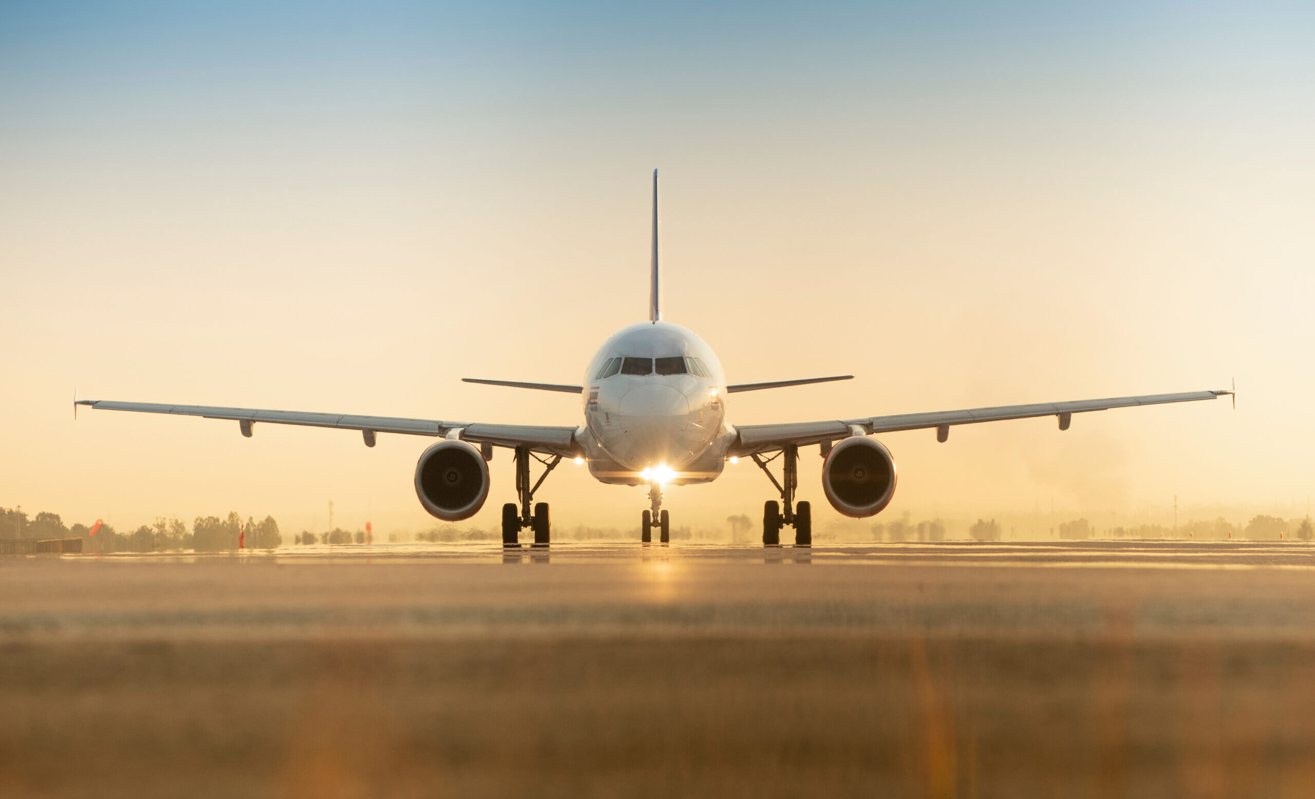 Sunset view of airplane on airport runway under dramatic sky