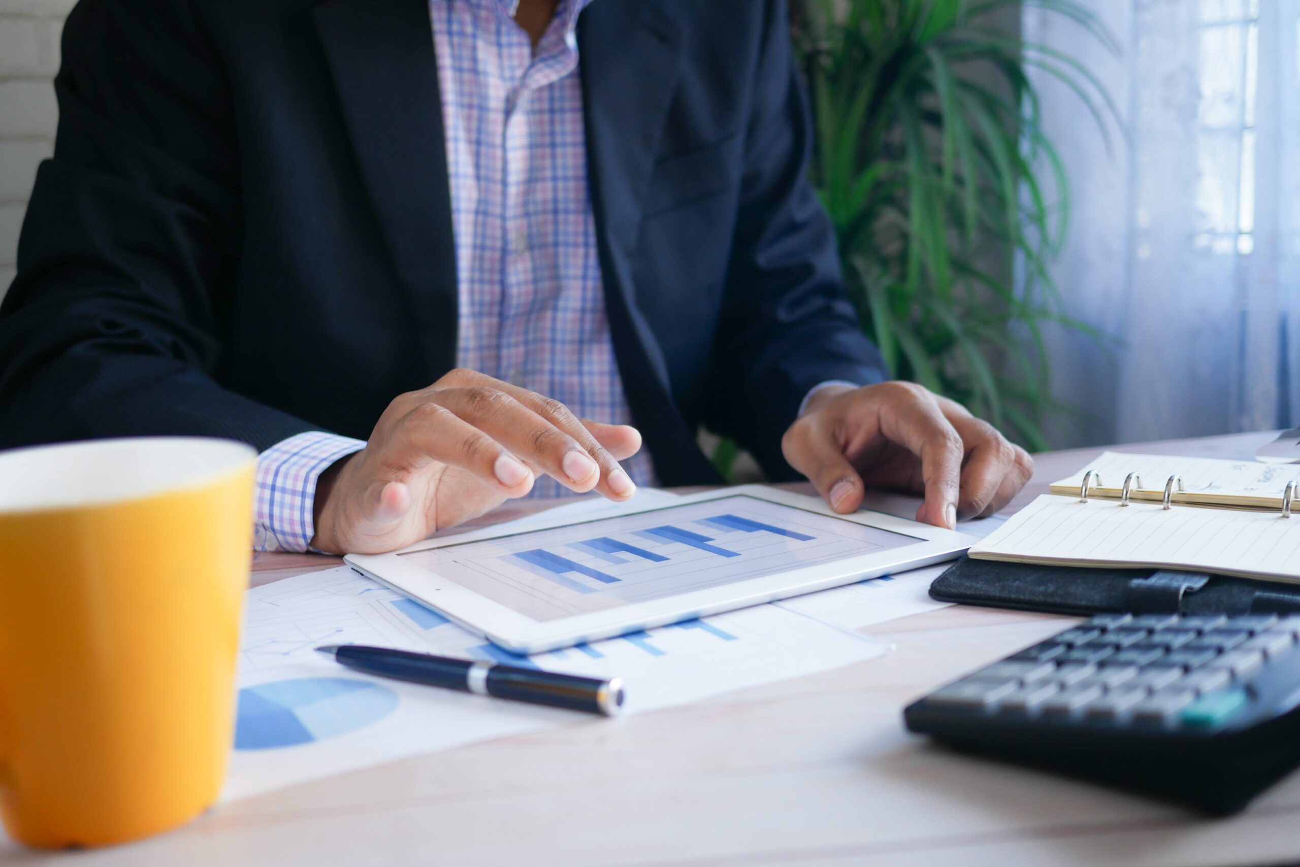 man in suit using tablet with bar chart displaying