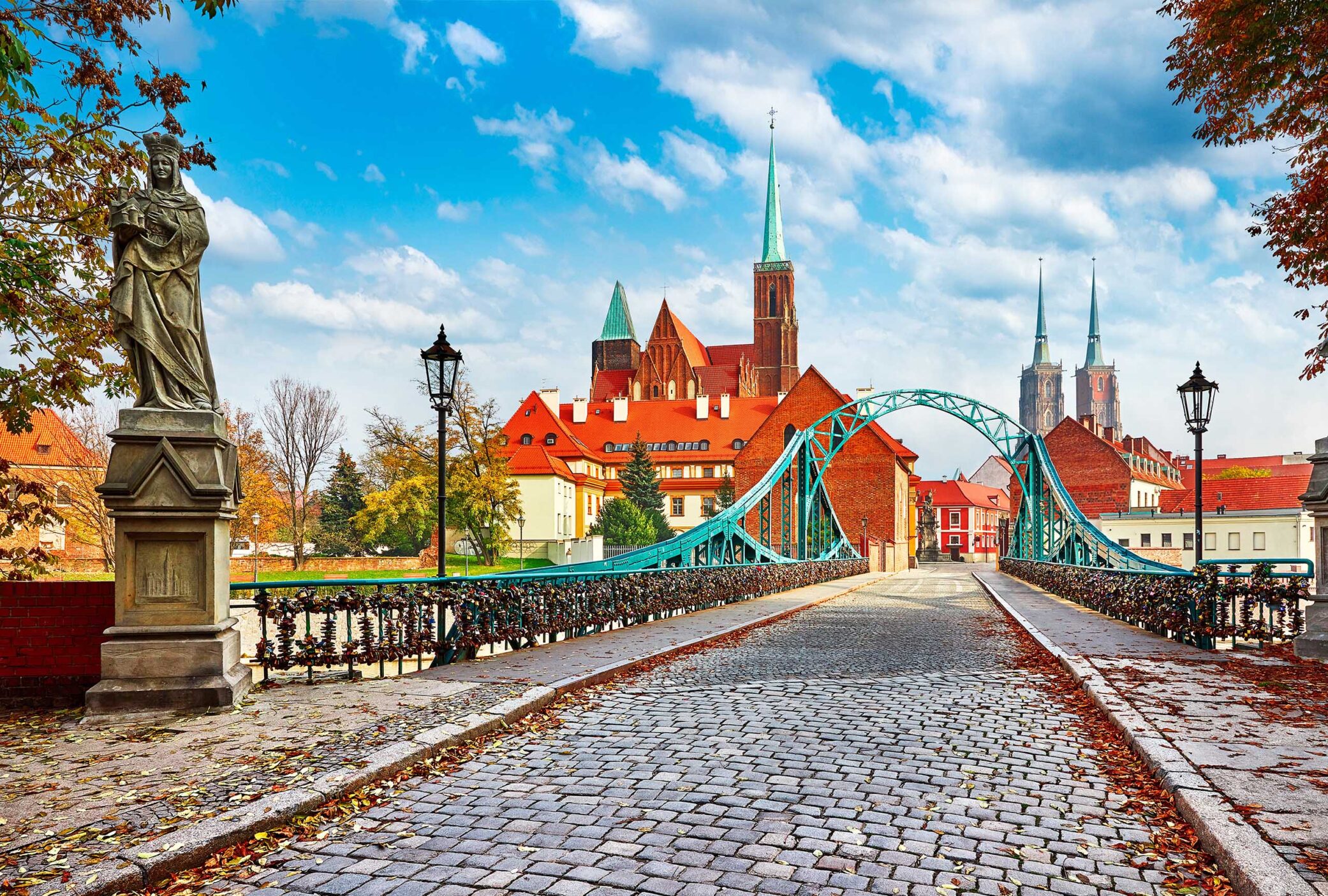 Cathedral Island in Wroclaw Poland green bridge with view on of St John the Baptist picturesque panorama medieval town blue sky and white cloud.