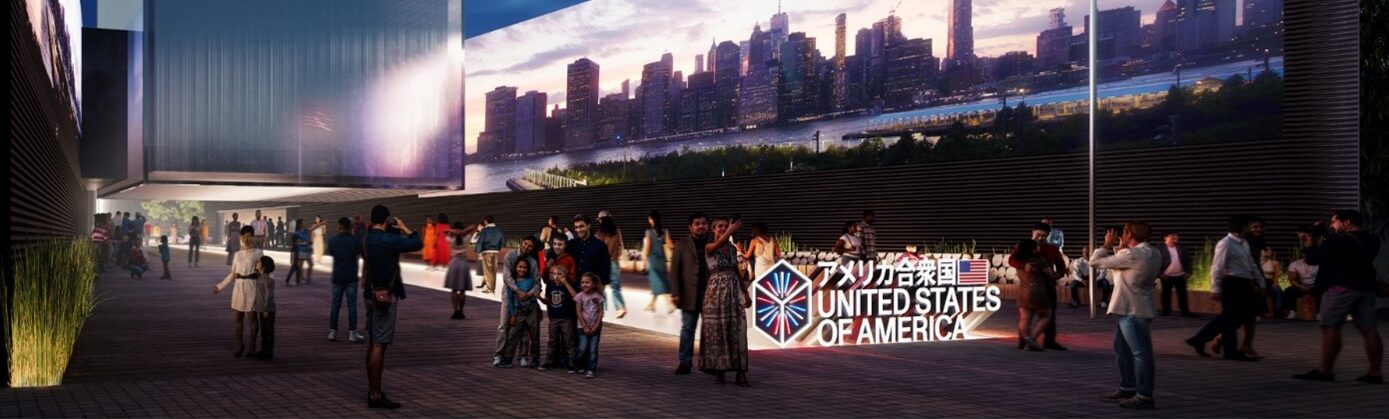 a modern building at night with a crowd outside. An American flag flies on the right, and a sign below reads "United States of America" with Japanese characters above. A city skyline is visible in the background.